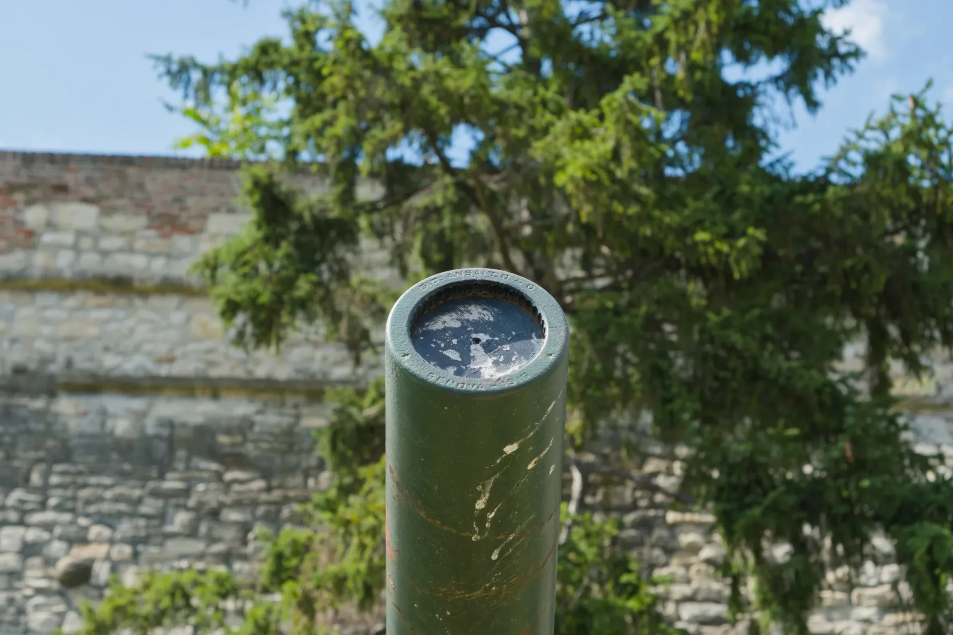 Museo all'aperto a Kalemegdan, Belgrado: cannone verde contro un muro di pietra e alberi.
