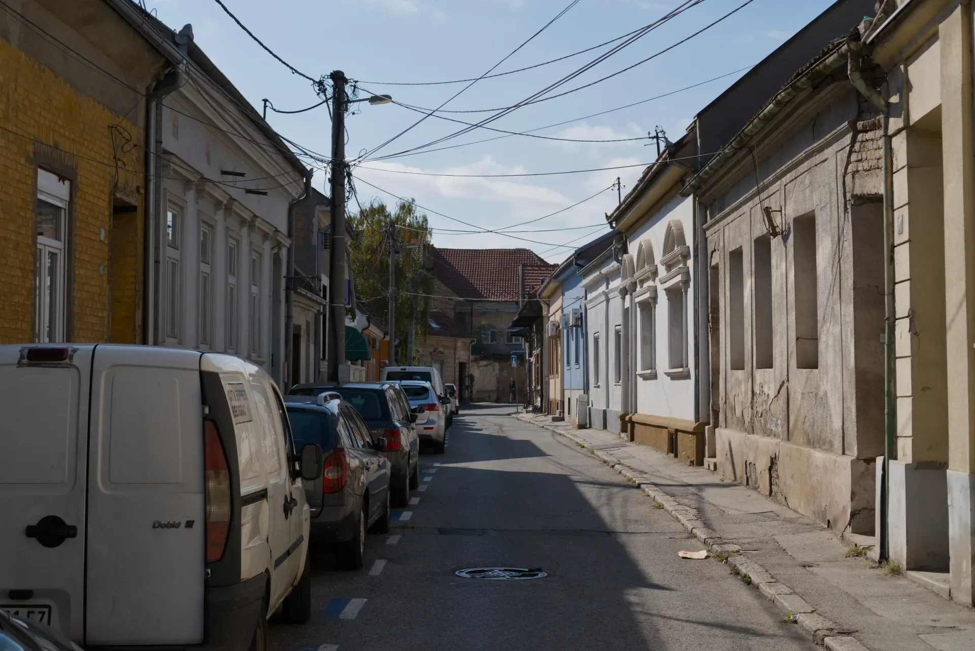 Picturesque Zemun street in Belgrade with row houses and parked cars, ideal for interior design.