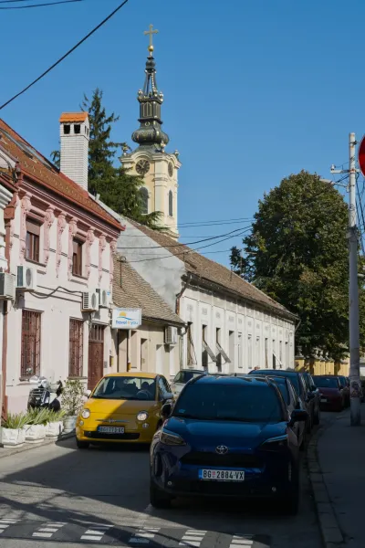 Portrait photograph of a street in Zemun, Belgrade, with historic buildings and a church tower.