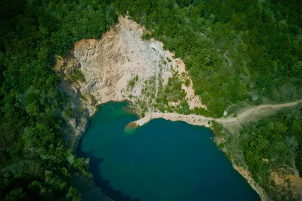 Ledinačko Lake from a bird's eye view, Serbia, with turquoise water and green trees.