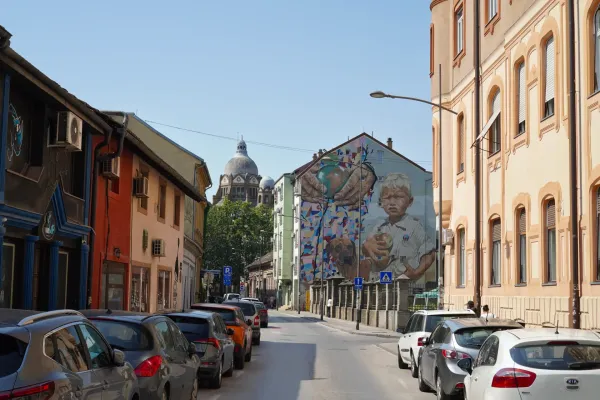 View of the Synagogue from Šafarikova Street in Novi Sad, with street art and architecture.