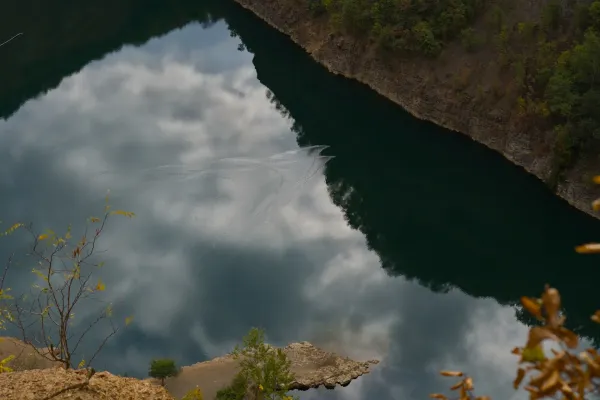 Ducks glide across Ledinačko Lake, leaving a wake on the water, aerial view