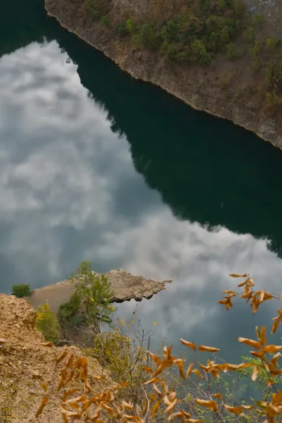 View of Lake Ledinačko from a cliff on the northwest bank, reflection of clouds in the water.